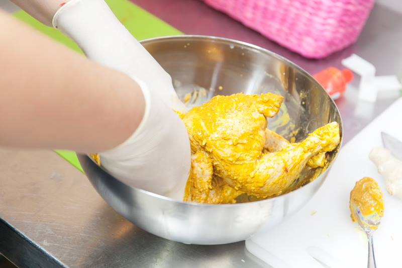 Beim Marinieren. Das Huhn gut mit der Marinade einmassieren. 